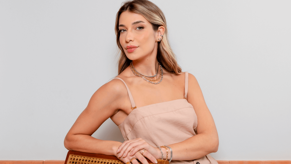 Modelo usando mix de semijoias para o Carnaval 2026, destacando mix de colares robustos no banho de ouro 18k e ródio branco, pulseiras e brincos.